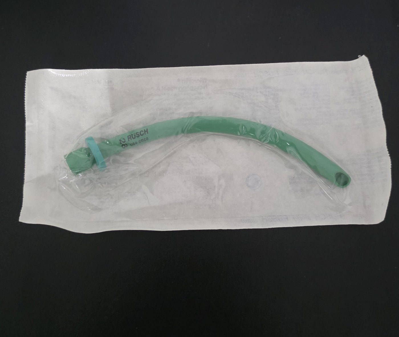 A nasopharyngeal airway in its wrapper. The tip has a beveled opening.